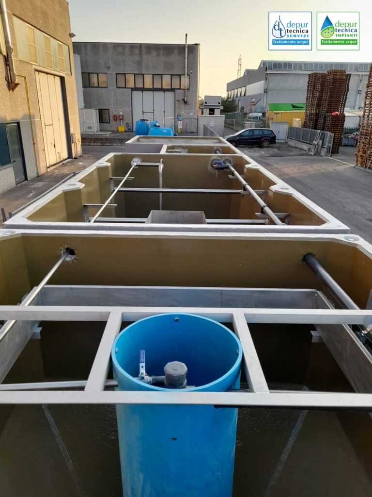 Vista dell’impianto dal comparto di sedimentazione finale (in primo piano) al comparto di pretrattamento/Imhoff; in primo piano cilindro di calma con ricircolo e canaletta di sfioro in acciaio inox AISI 304 | DEPURTECNICA